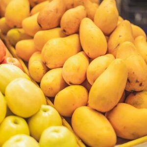 A vibrant display of fresh apples and mangoes in a supermarket's fruit section.